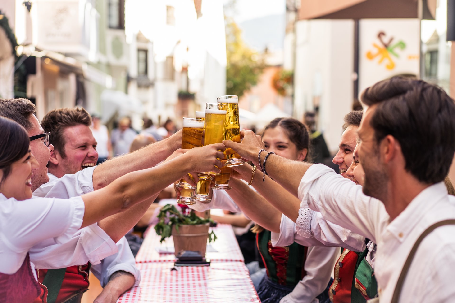 Gäste stoßen an der langen Tafel mit Bier an