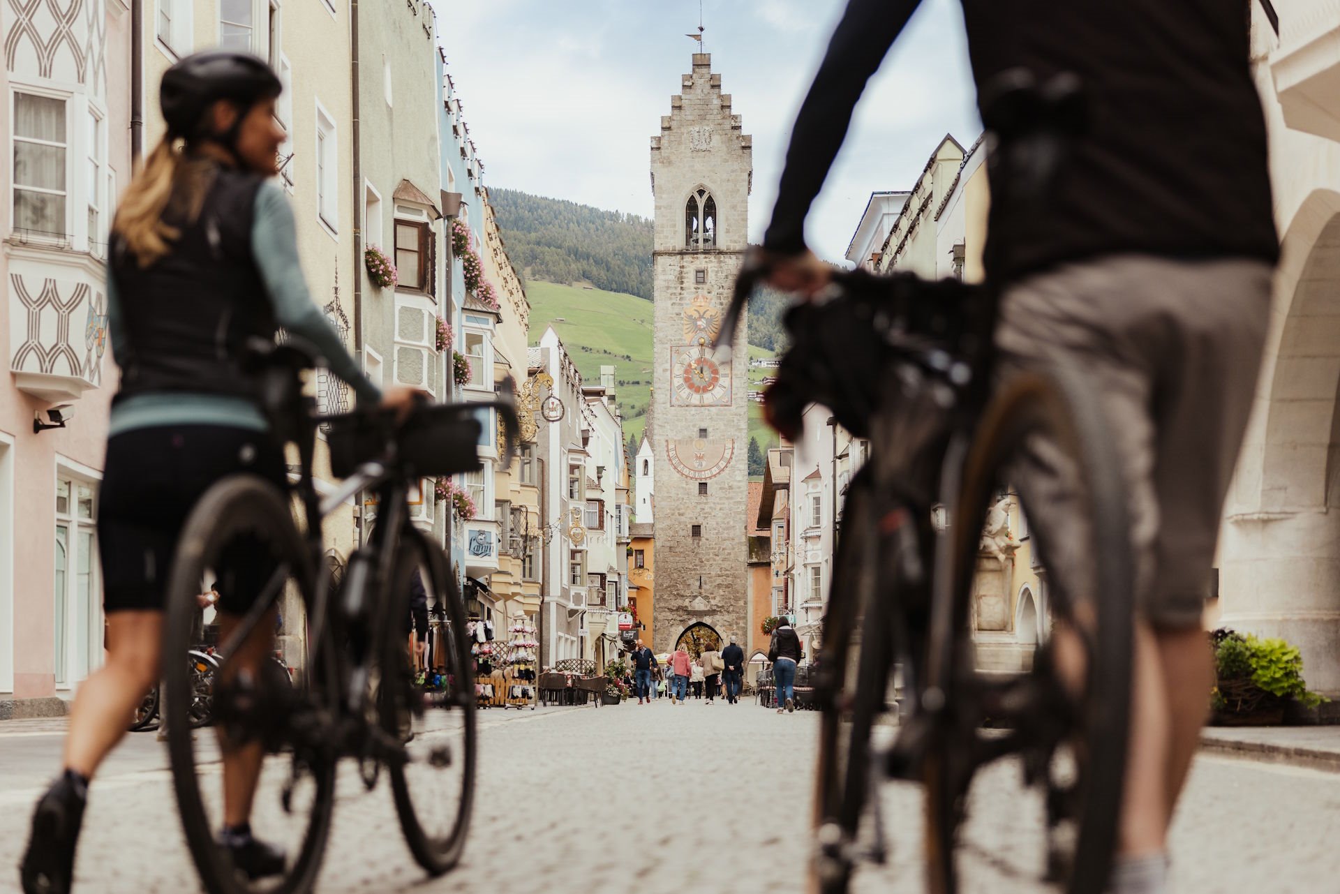 Zwei Radfahrer schieben ihre Räder durch die Neustadt zum Zwölferturm